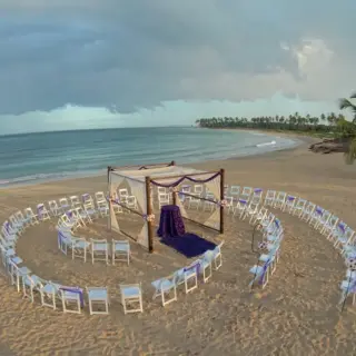 Beach wedding ceremony with a circular spiral of chairs and a wooden gazebo at Breathless Punta Cana, Punta Cana