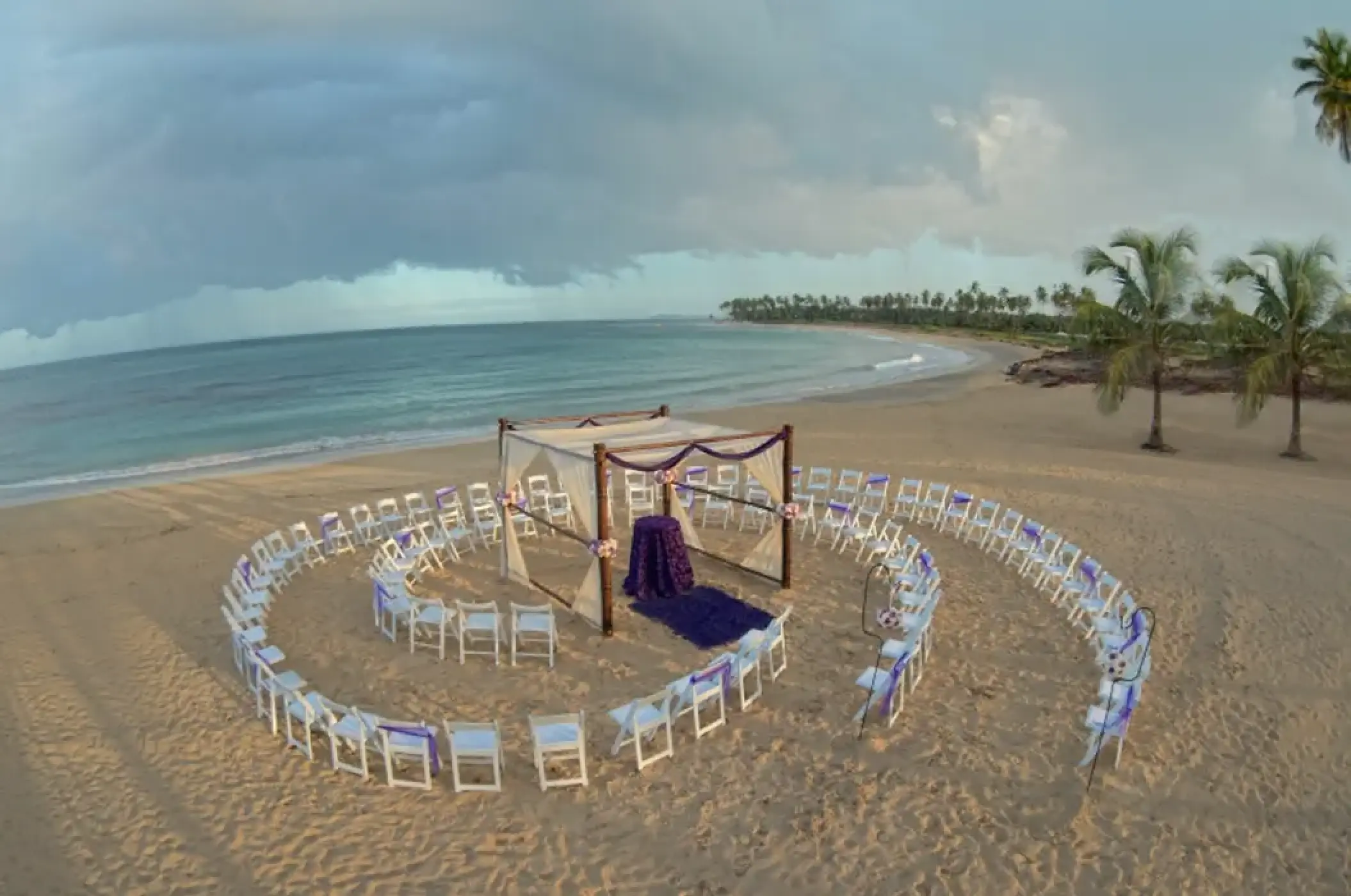 Beach wedding ceremony with a circular spiral of chairs and a wooden gazebo at Breathless Punta Cana, Punta Cana