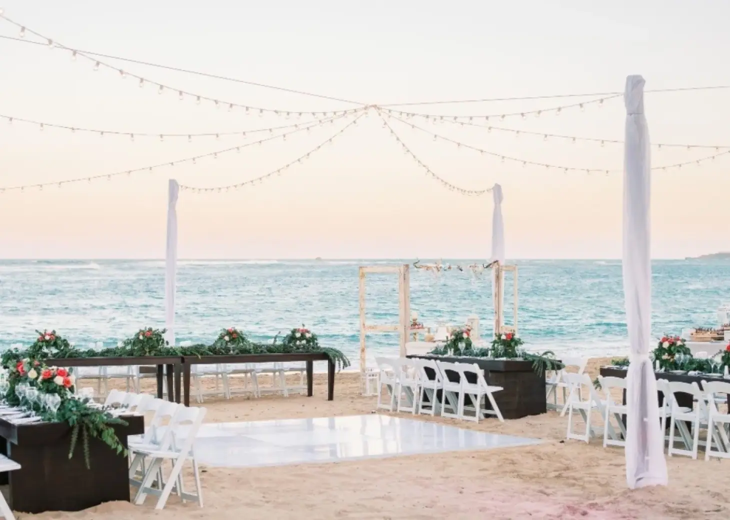 Beachfront wedding reception setup with dance floor and string lights at Breathless Punta Cana, Punta Cana