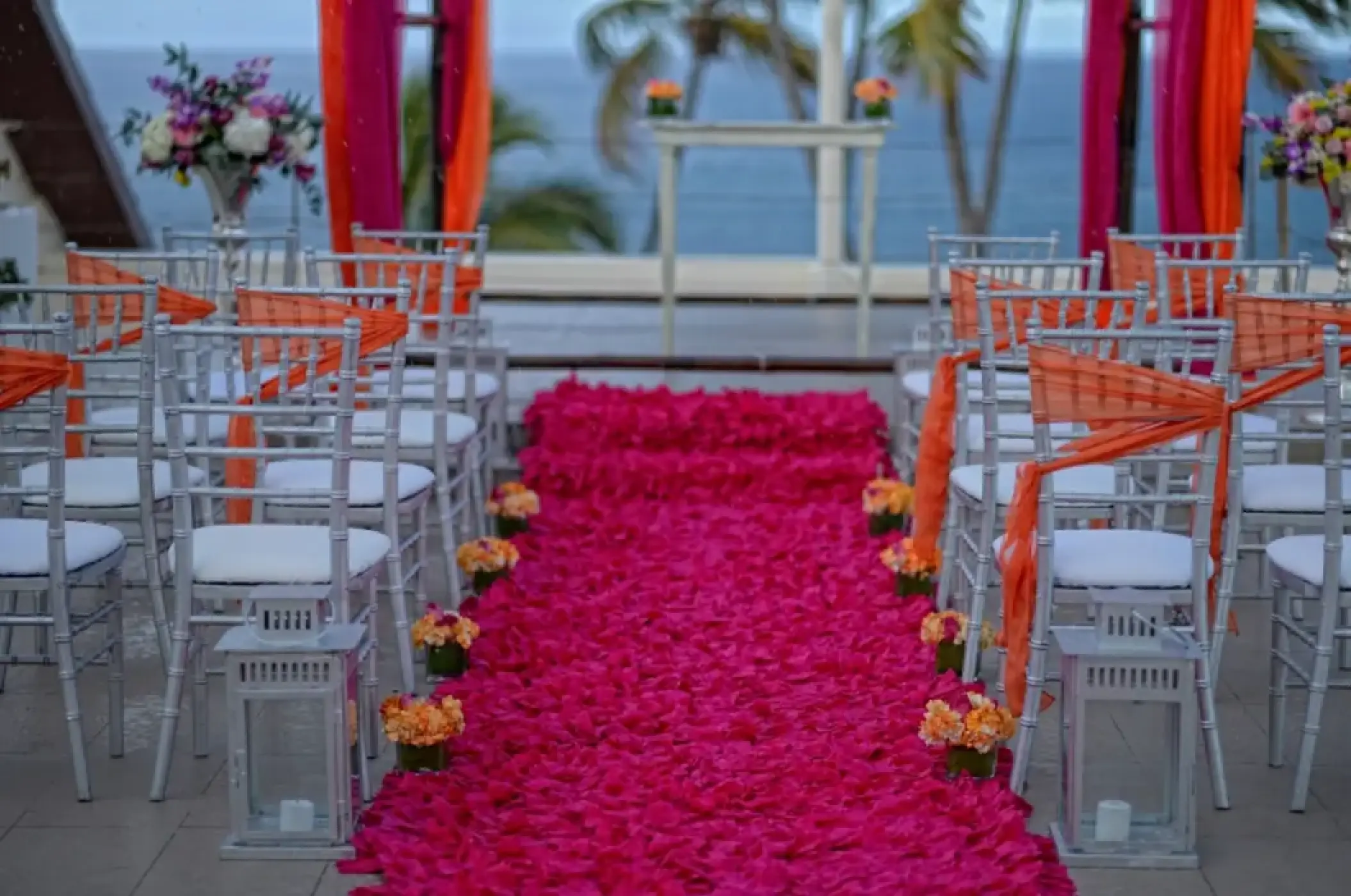 Rooftop wedding ceremony with pink flower petal aisle and orange sashes at Breathless Punta Cana