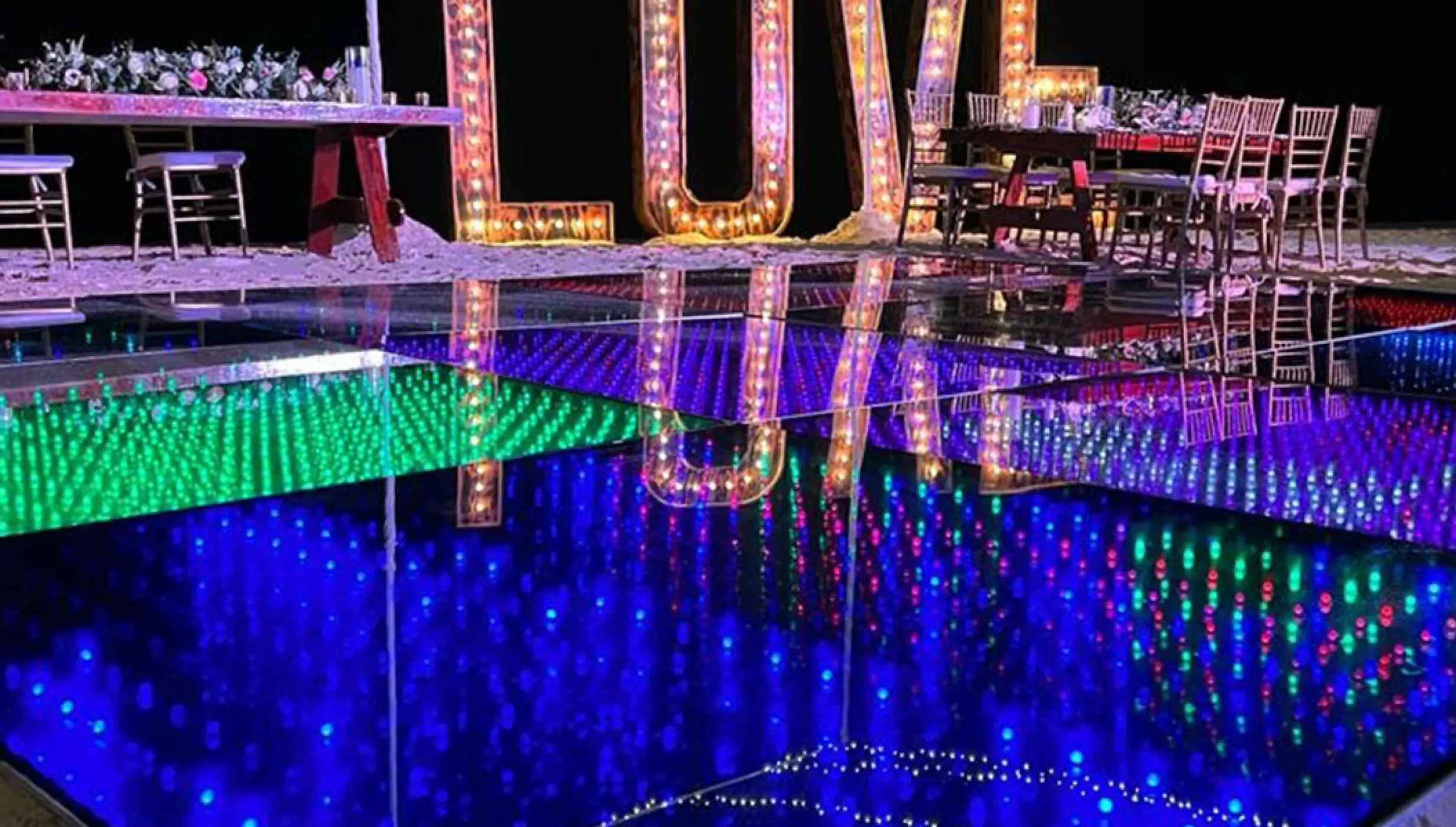 Marquee LOVE sign reflected in a lighted dance floor at a Breathless Riviera Cancun reception, Riviera Maya