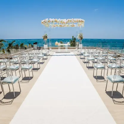 Rooftop wedding ceremony with floral arch overlooking the ocean at Breathless Riviera Cancun, Riviera Maya