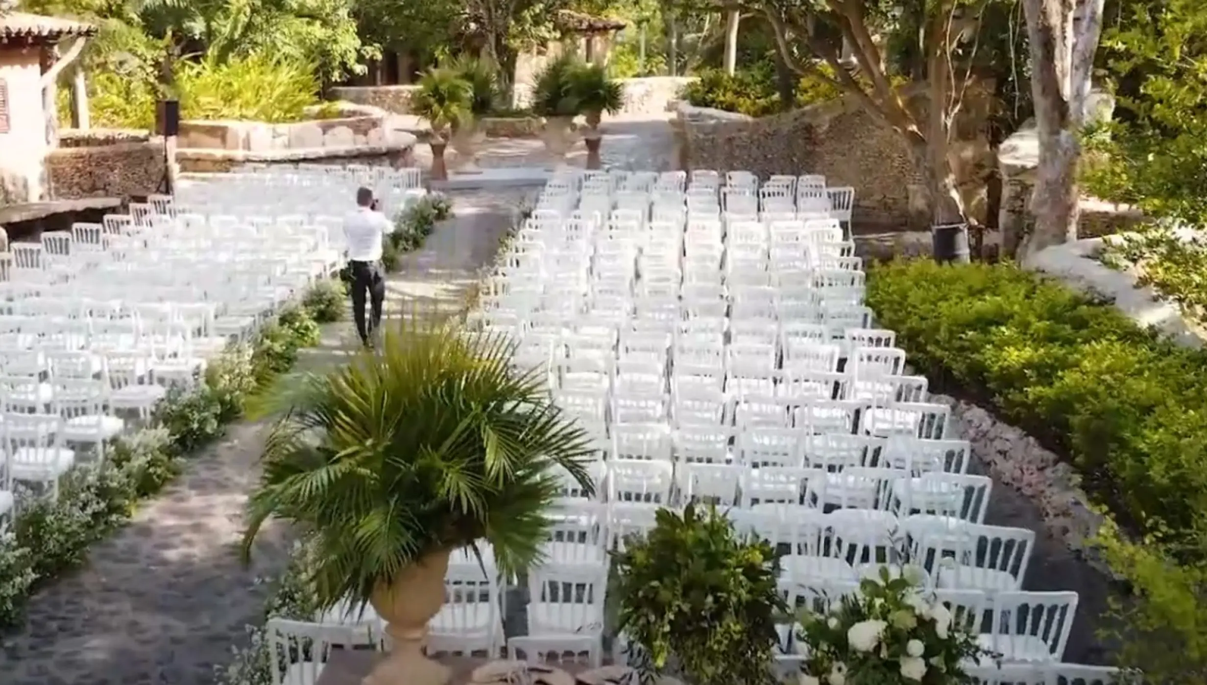 Garden wedding ceremony setup with rows of white chairs at Casa de Campo, La Romana