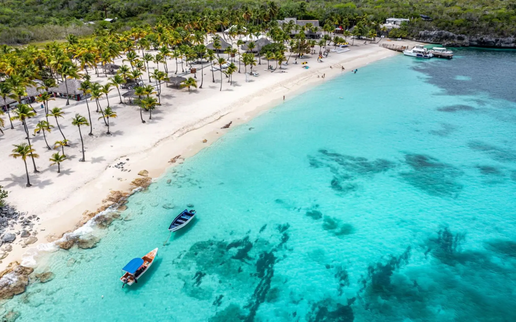 Aerial view of Minitas Beach with palm trees and turquoise water at Casa de Campo, La Romana