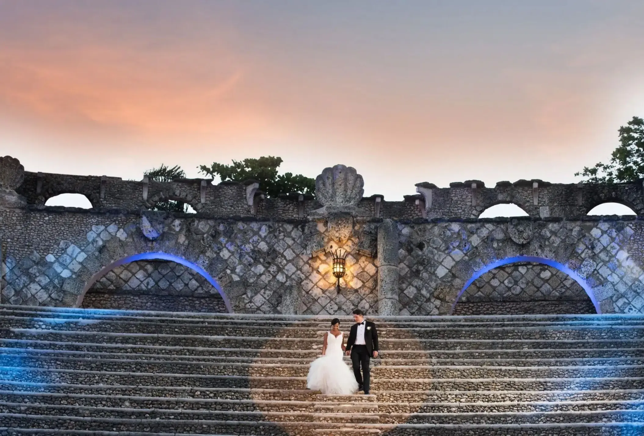 The bride and groom walking down the stone amphitheater steps at Casa de Campo, La Romana