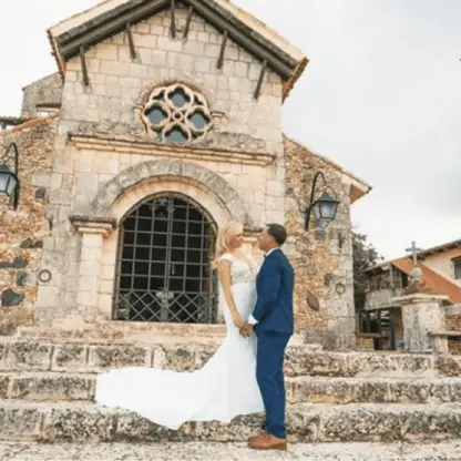 Bride and groom standing on the stone steps of the Altos de Chavón chapel at Casa de Campo, La Romana