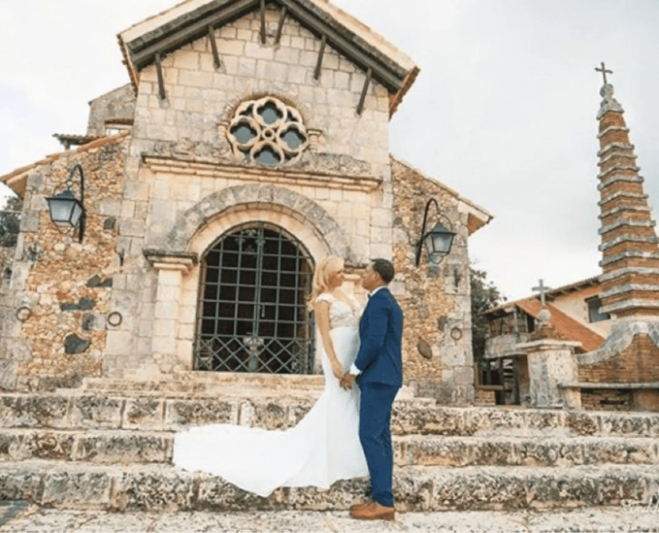 Bride and groom standing on the stone steps of the Altos de Chavón chapel at Casa de Campo, La Romana