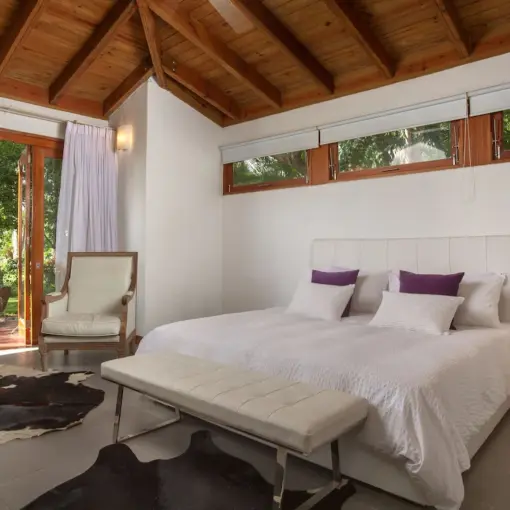 Four-bedroom garden villa bedroom with wooden vaulted ceiling at Casa de Campo, La Romana