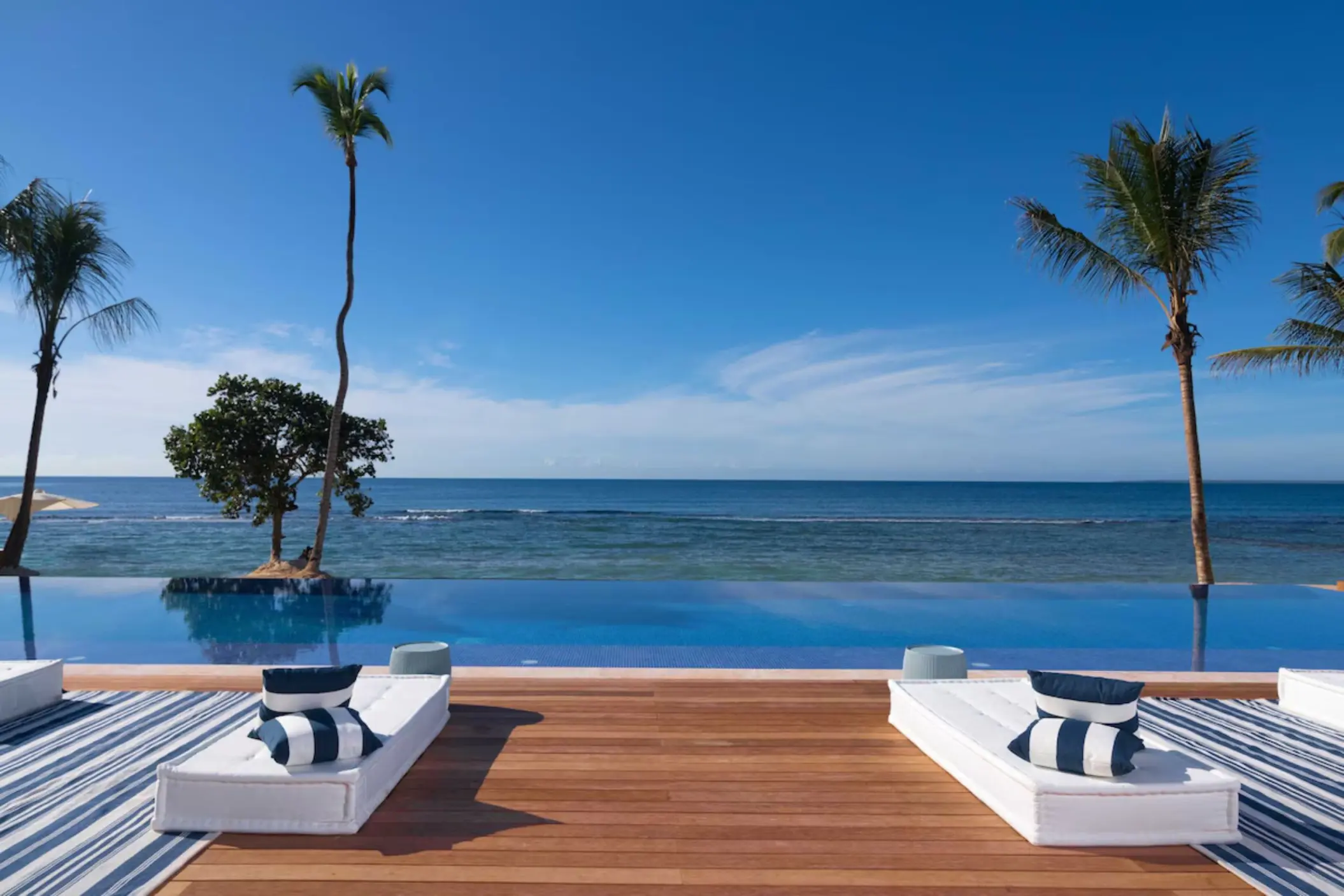 Infinity pool and wooden deck with lounge chairs at Casa de Campo, La Romana