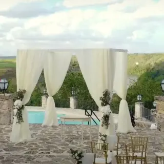 Stone terrace wedding ceremony with white draped gazebo at Casa de Campo, La Romana