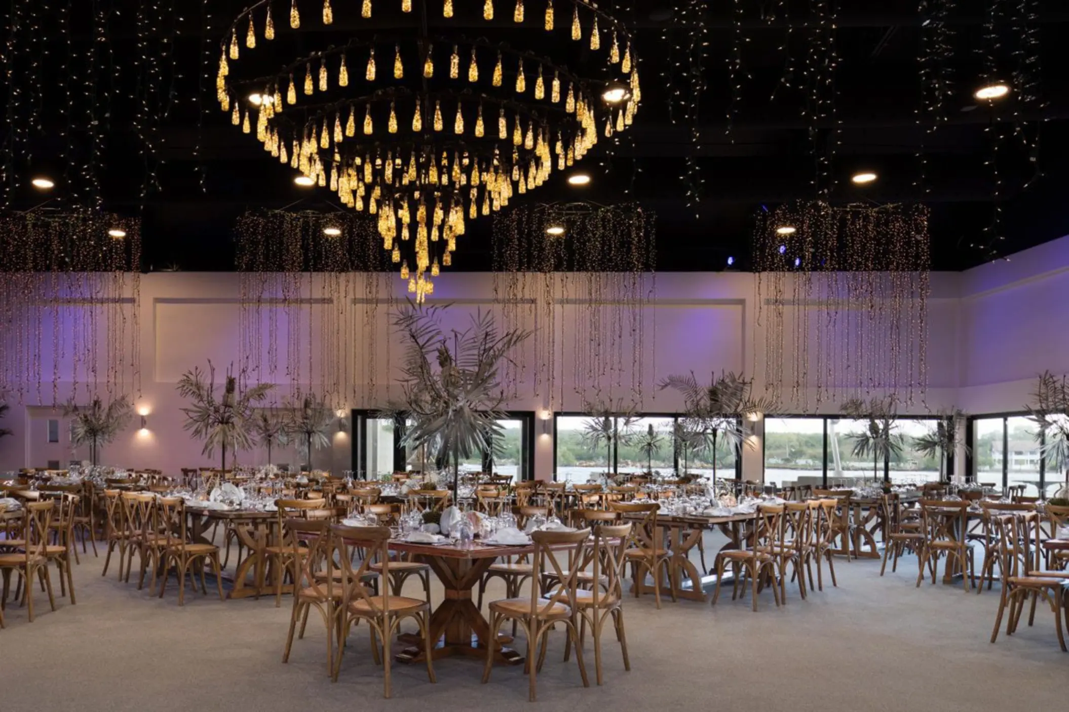 Indoor wedding reception with a large chandelier and string lights at Casa de Campo, La Romana
