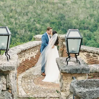 Bride and groom kissing on a stone terrace at Casa de Campo, La Romana