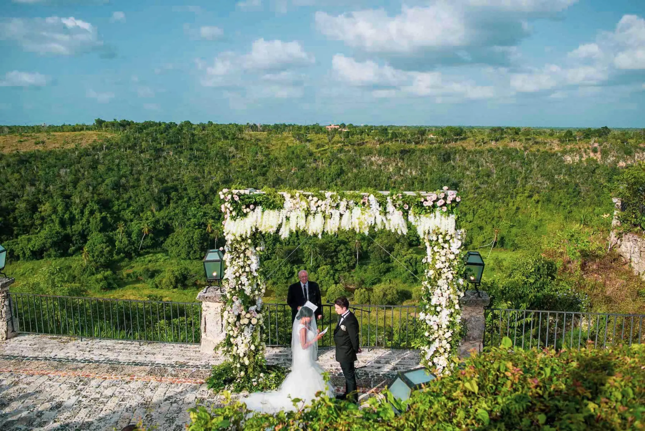 Outdoor wedding ceremony under a floral arch at Casa de Campo, La Romana