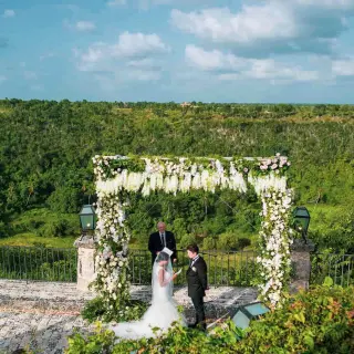 Outdoor wedding ceremony under a floral arch at Casa de Campo, La Romana