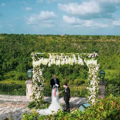 Outdoor wedding ceremony under a floral arch at Casa de Campo, La Romana