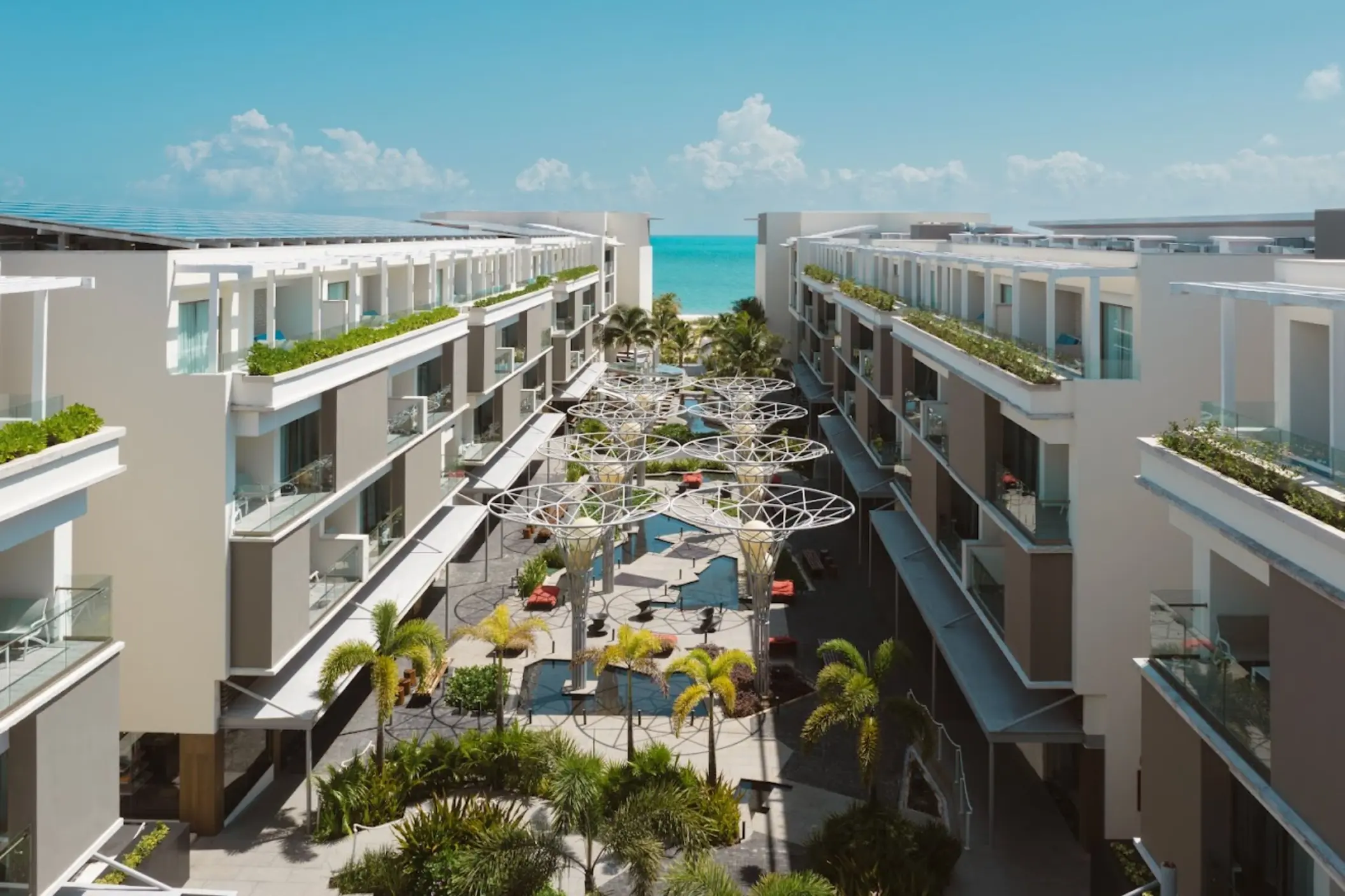 Aerial view of the Fifth Avenue promenade and modern guest buildings at Catalonia Grand Costa Mujeres, Cancun