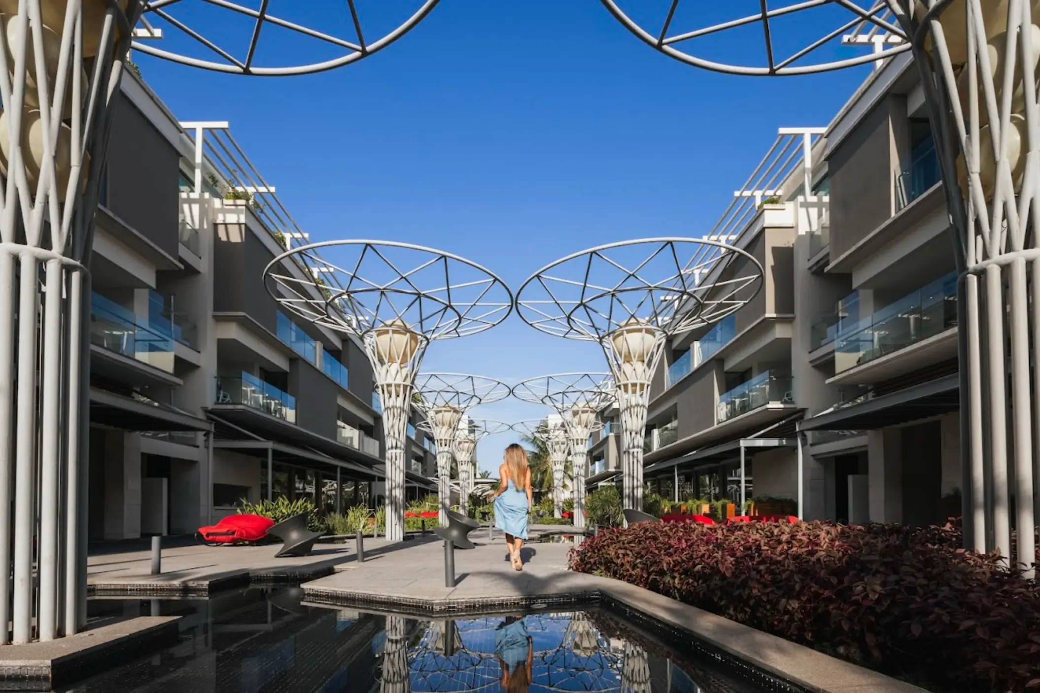 Modern promenade with decorative white structures and reflecting pools at Catalonia Grand Costa Mujeres, Cancun