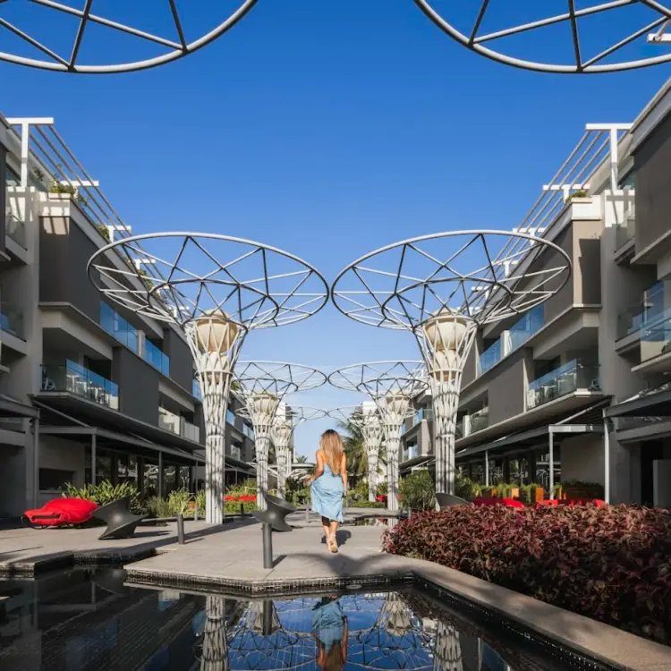 Modern promenade with decorative white structures and reflecting pools at Catalonia Grand Costa Mujeres, Cancun