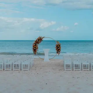 Beachfront wedding ceremony with a floral circle arch at Catalonia Grand Costa Mujeres, Cancun