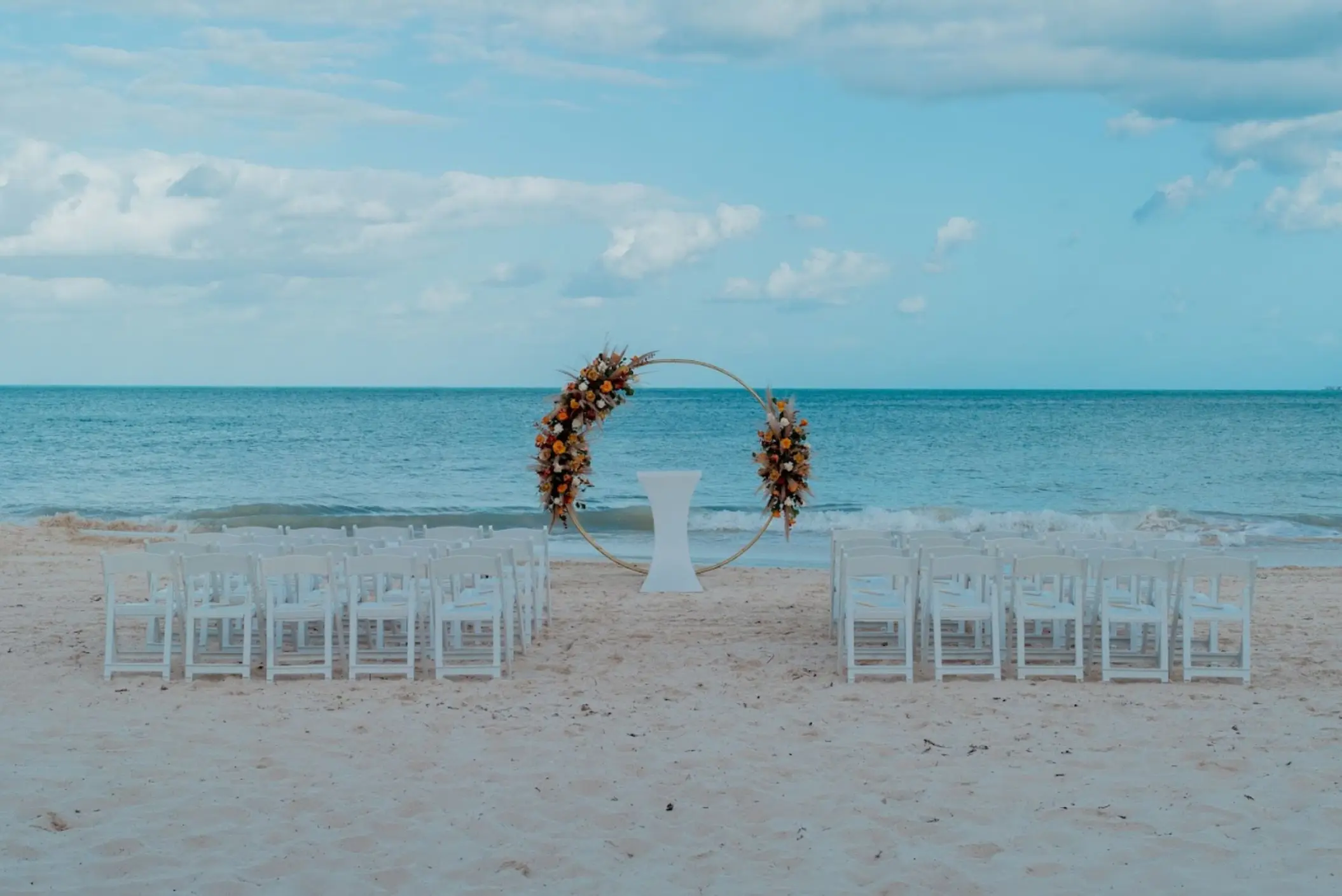 Beachfront wedding ceremony with a floral circle arch at Catalonia Grand Costa Mujeres, Cancun
