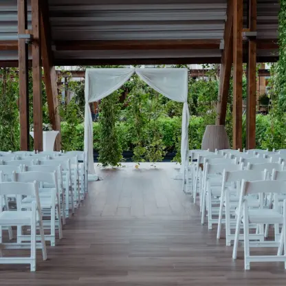 Wedding ceremony setup with white chairs and fabric arch under a wooden pavilion at Catalonia Grand Costa Mujeres, Cancun