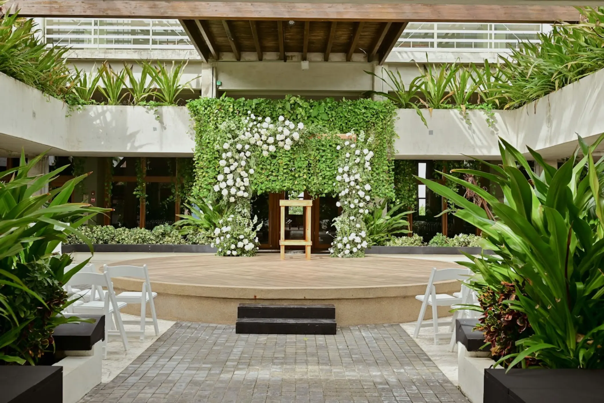 Garden wedding ceremony setup with white floral arch at Catalonia Grand Costa Mujeres, Cancun