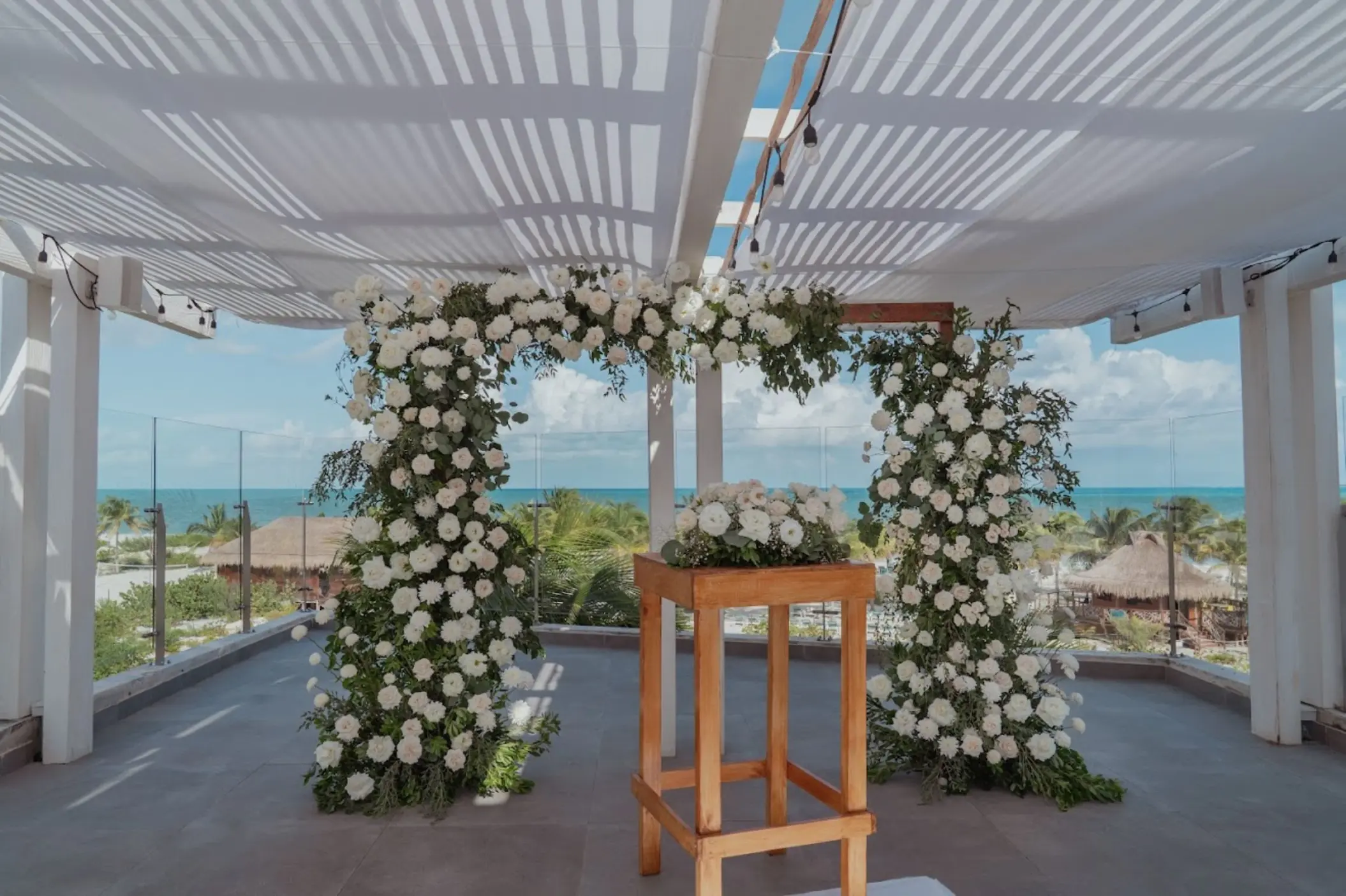 Rooftop wedding ceremony setup with white rose arch at Catalonia Grand Costa Mujeres, Cancun