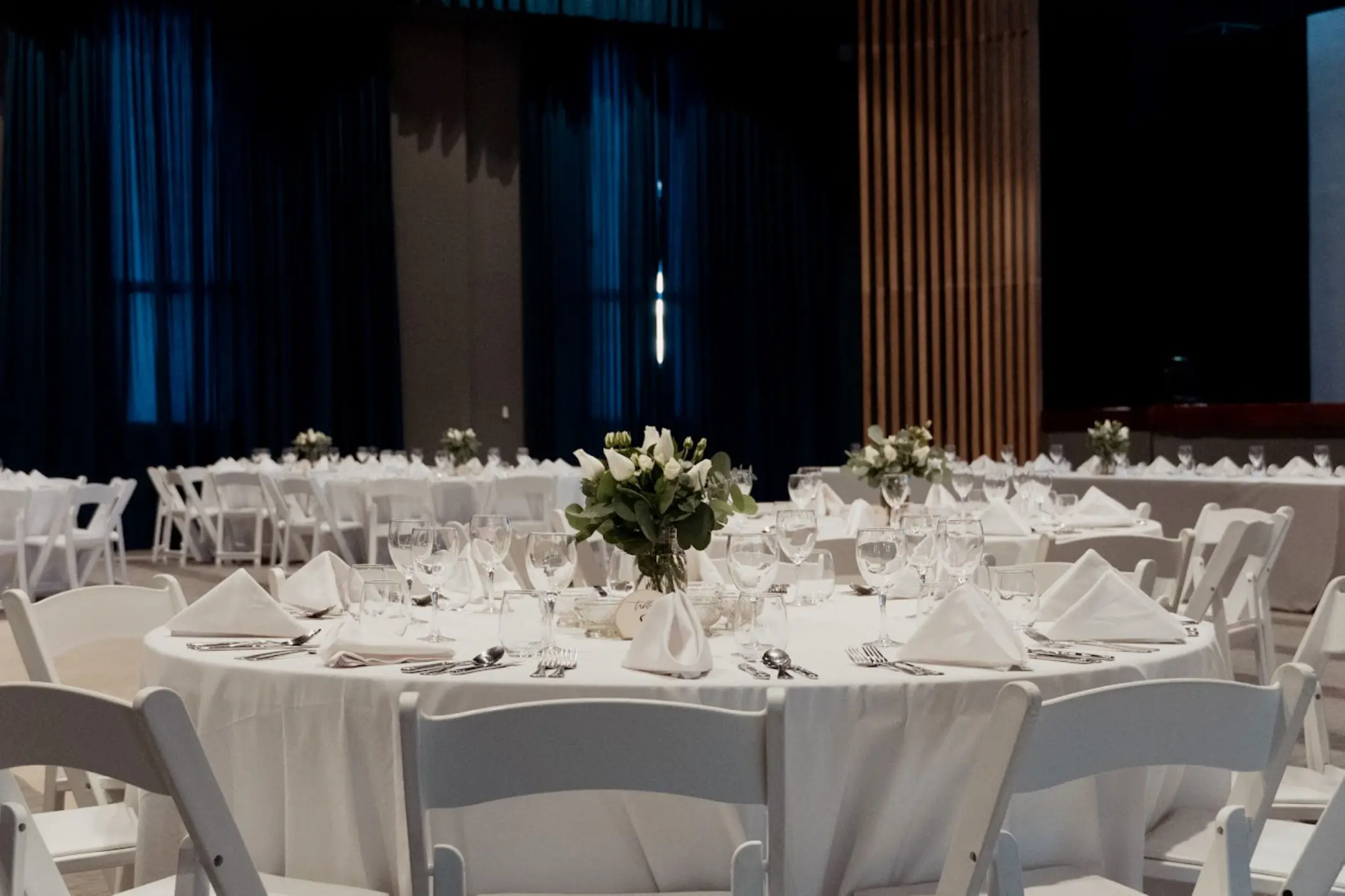 Indoor theater wedding reception with white linens and floral centerpieces at Catalonia Grand Costa Mujeres, Cancun