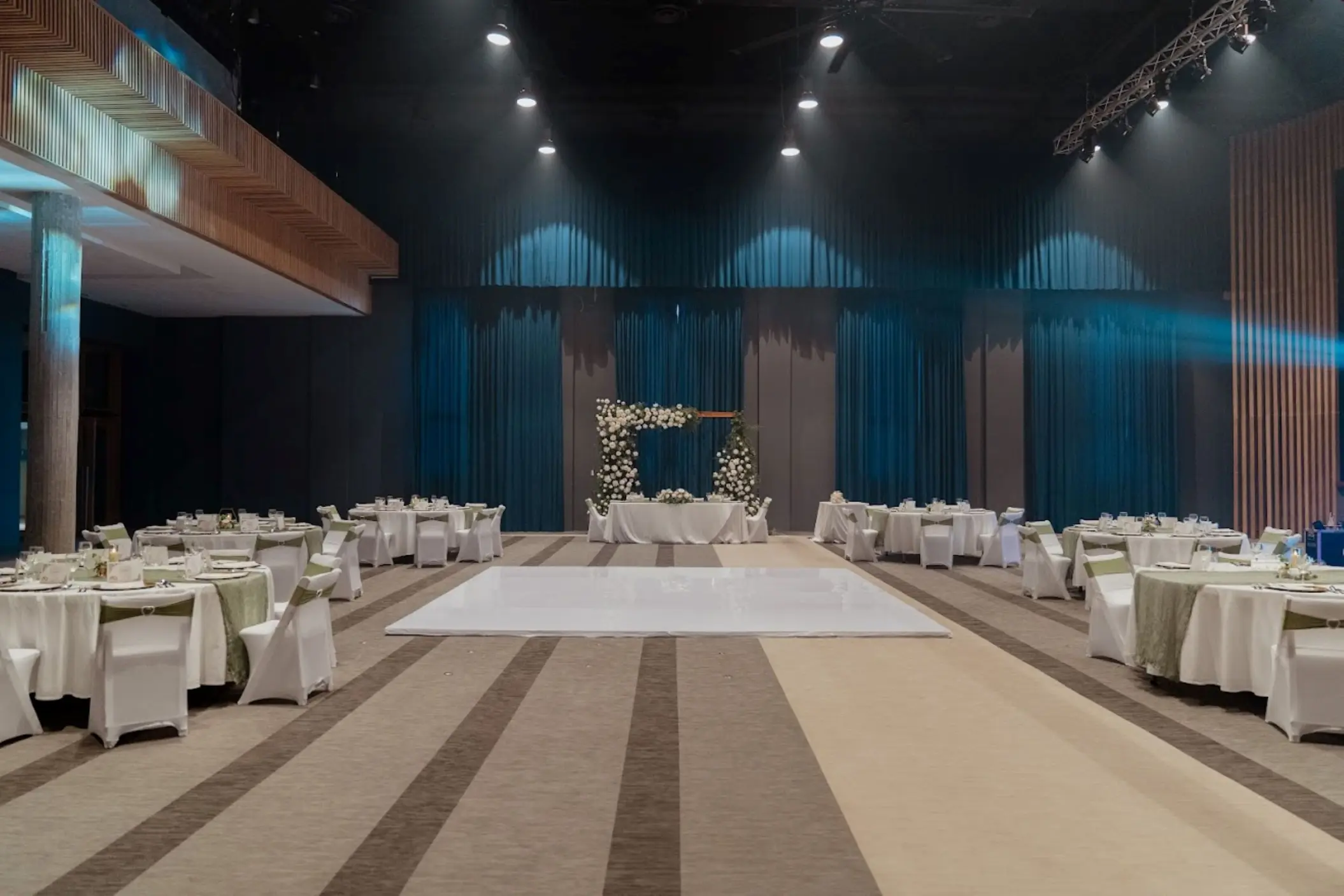 Indoor theater wedding reception with white dance floor and round tables at Catalonia Grand Costa Mujeres, Cancun