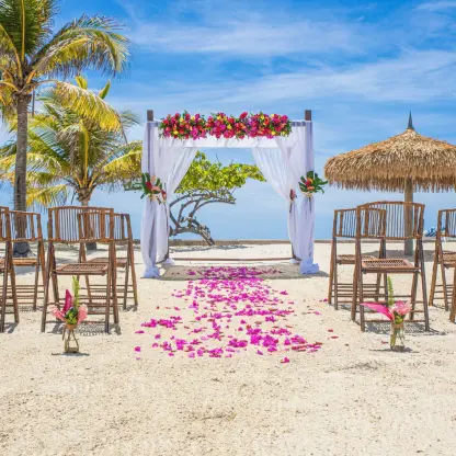 Beachfront wedding ceremony with a floral arch and bamboo chairs at Catalonia Montego Bay