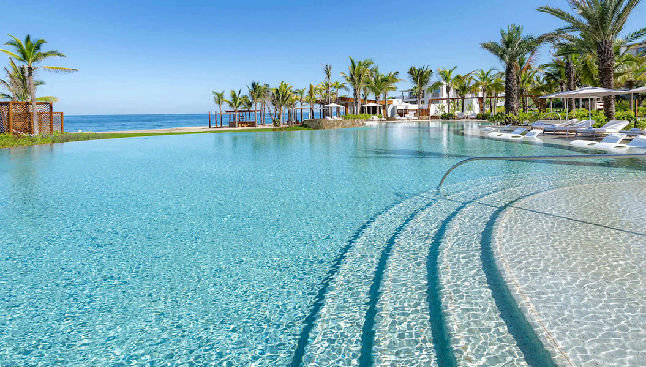Infinity pool with palm trees overlooking the ocean at Conrad Punta de Mita, Puerto Vallarta