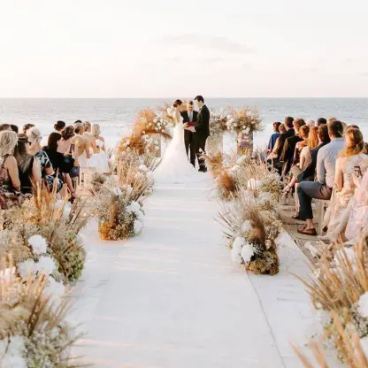 Beachfront wedding ceremony with white aisle and pampas grass at Conrad Punta de Mita, Puerto Vallarta