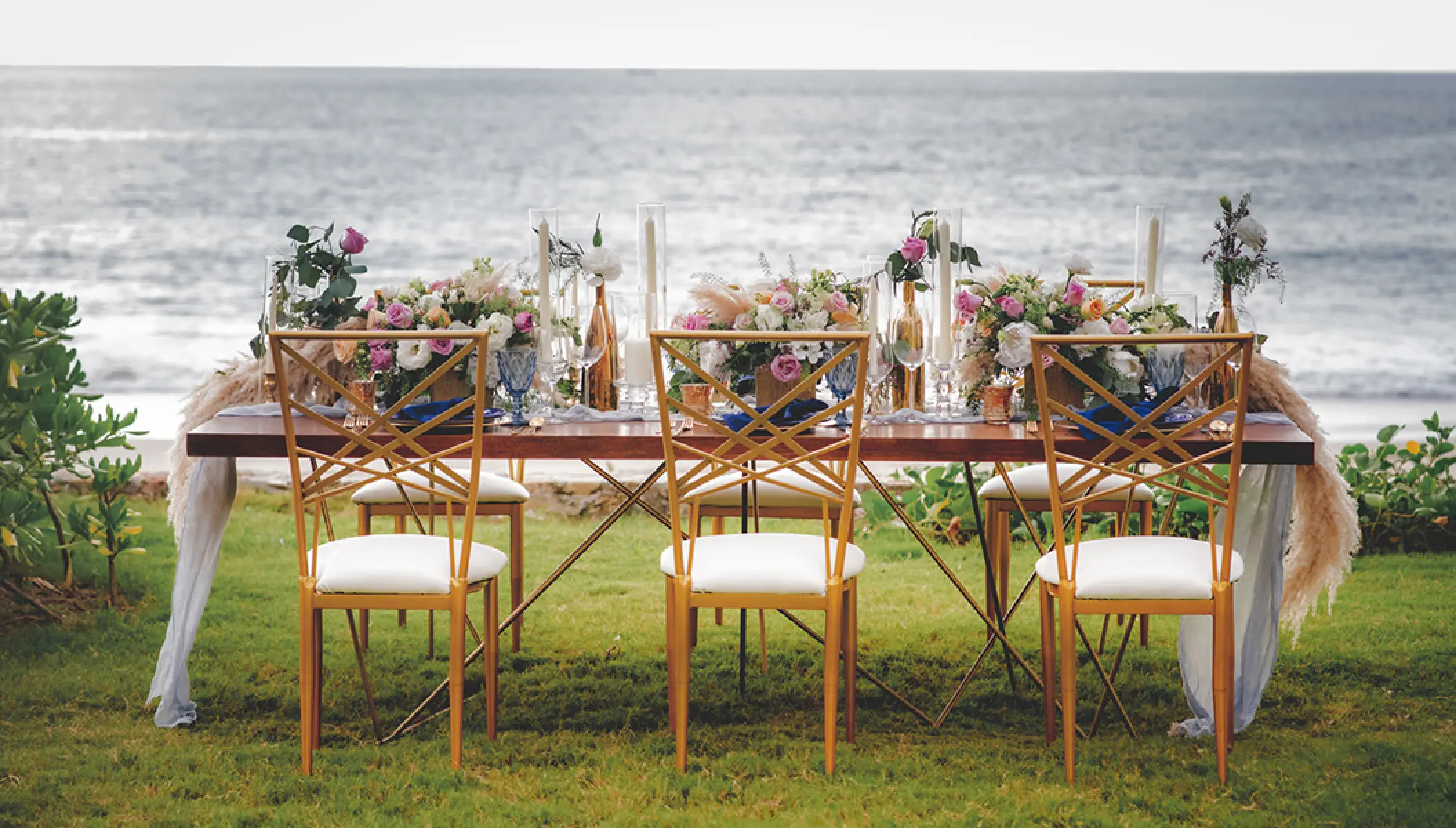 Outdoor wedding reception setup with gold chairs and floral centerpieces at Conrad Punta de Mita, Puerto Vallarta