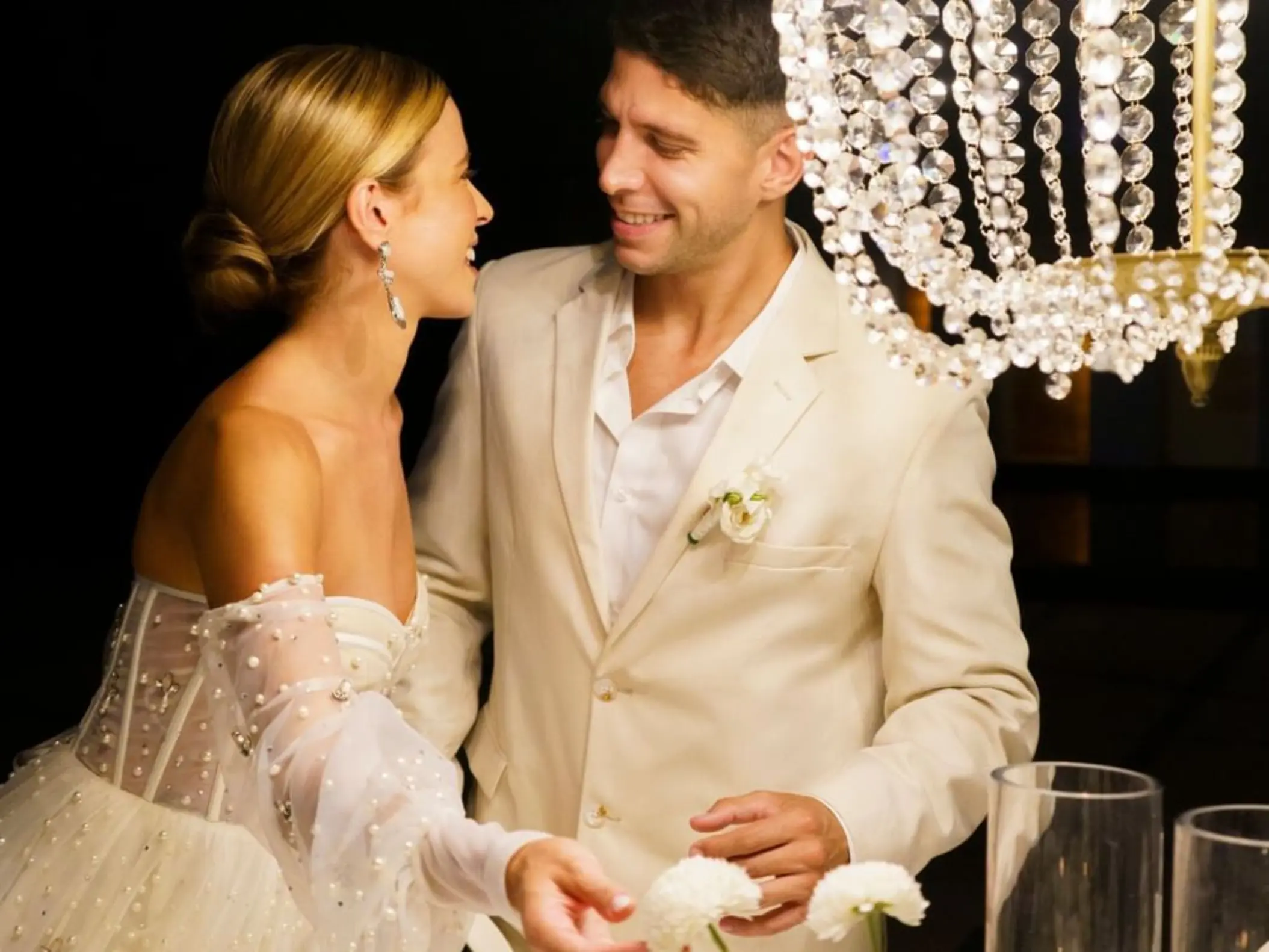 Bride and groom sharing a moment by a crystal chandelier at Devossion by Live Aqua, Playa Del Carmen