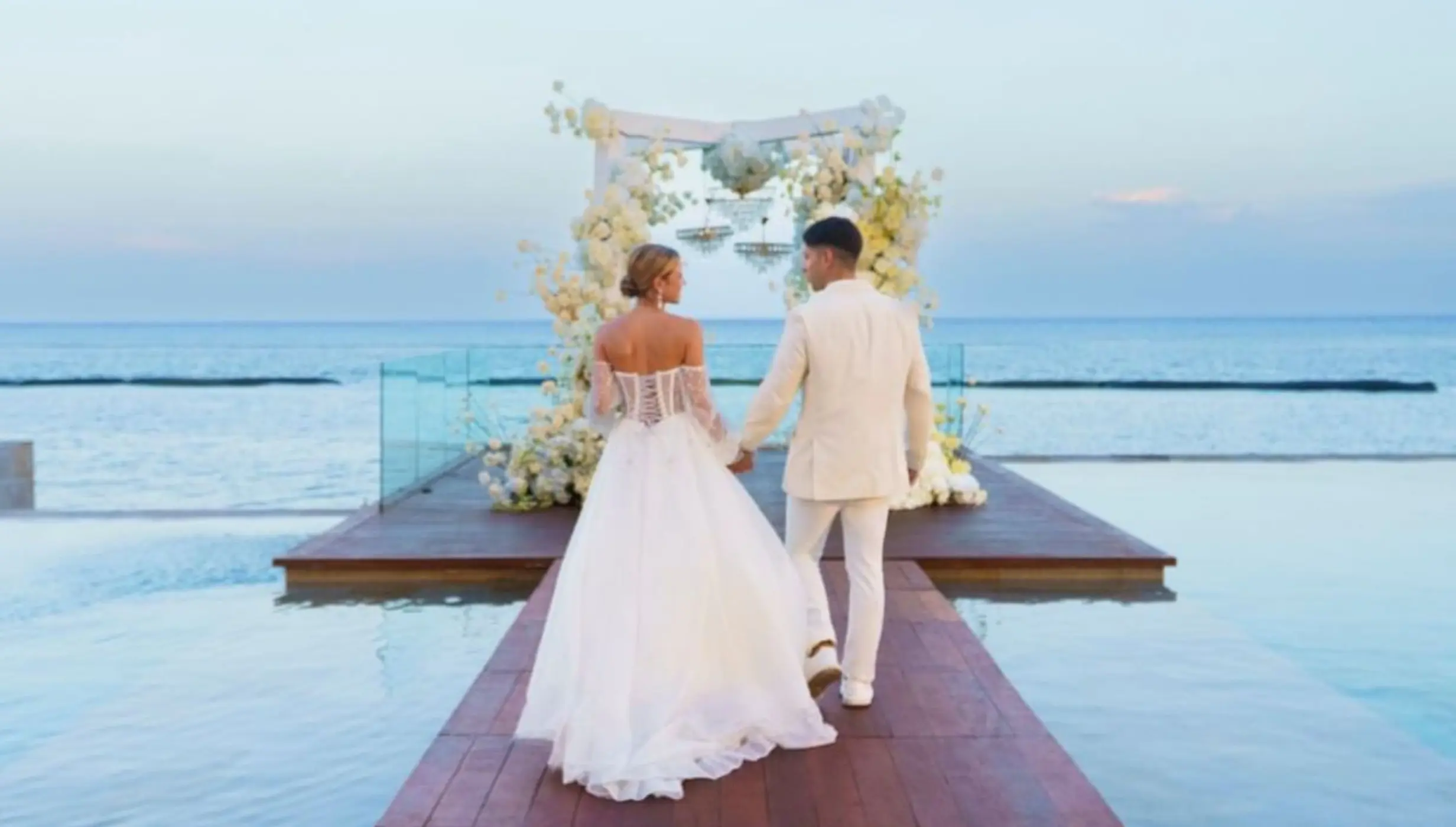 The couple walking towards an floral altar at Devossion by Live Aqua, Playa Del Carmen