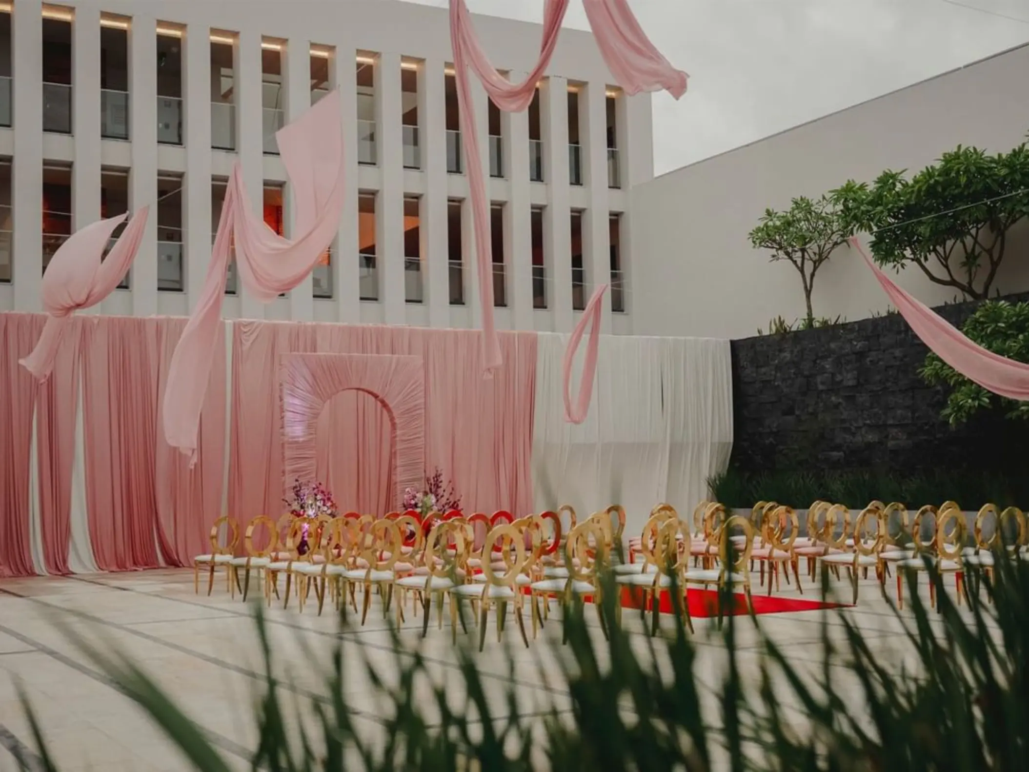 Citrus Patio wedding ceremony with pink draping and gold chairs at Live Aqua Playa del Carmen
