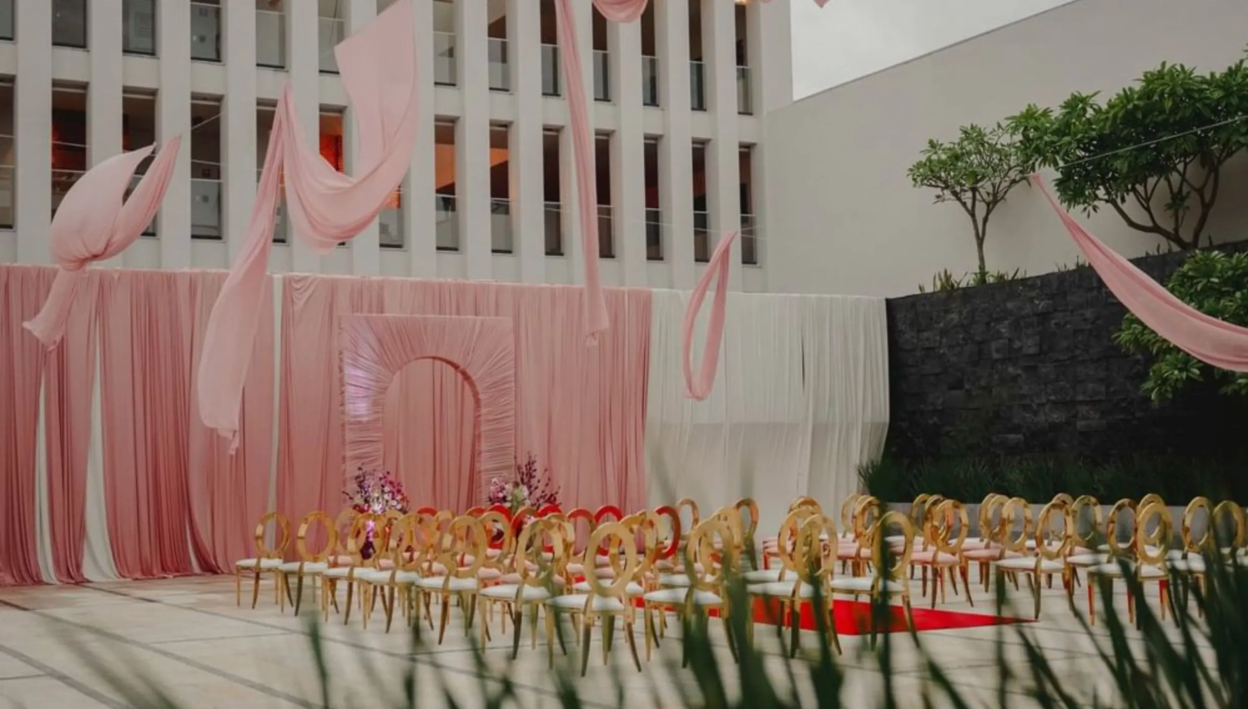 Citrus Patio wedding ceremony with pink draping and gold chairs at Live Aqua Playa del Carmen