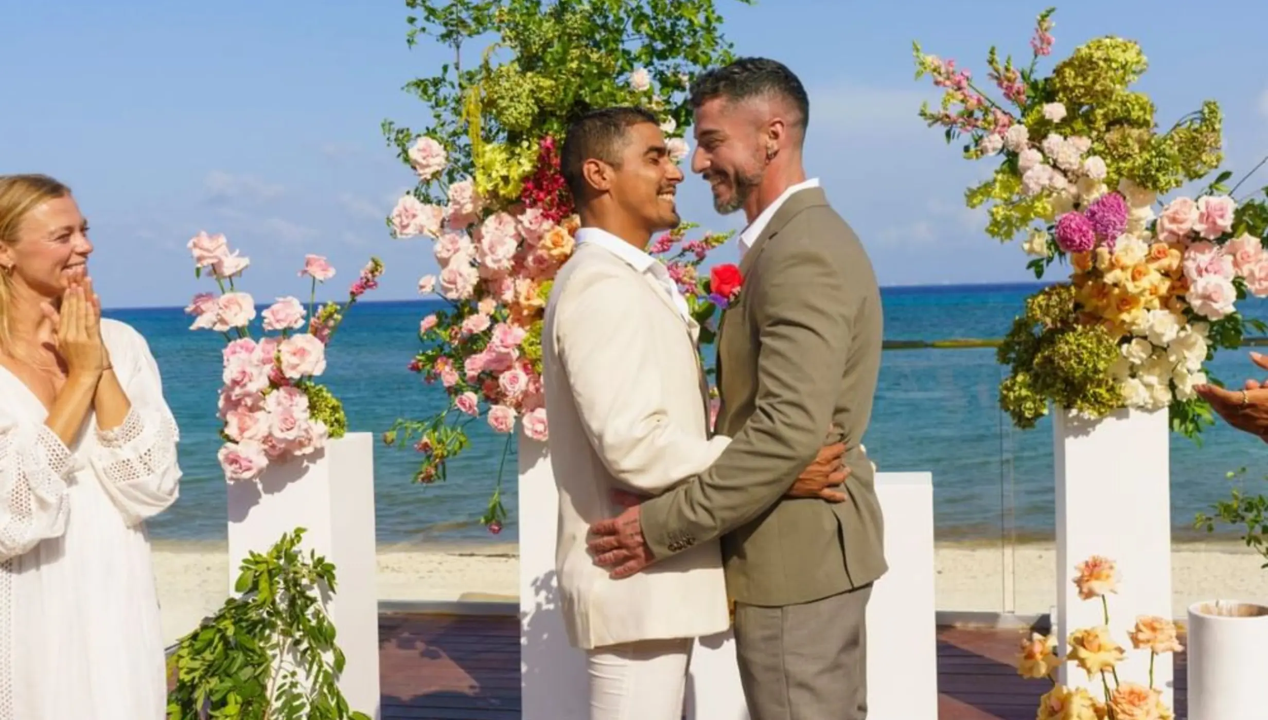 Grooms embracing at a beachfront wedding ceremony, Live Aqua Playa del Carmen