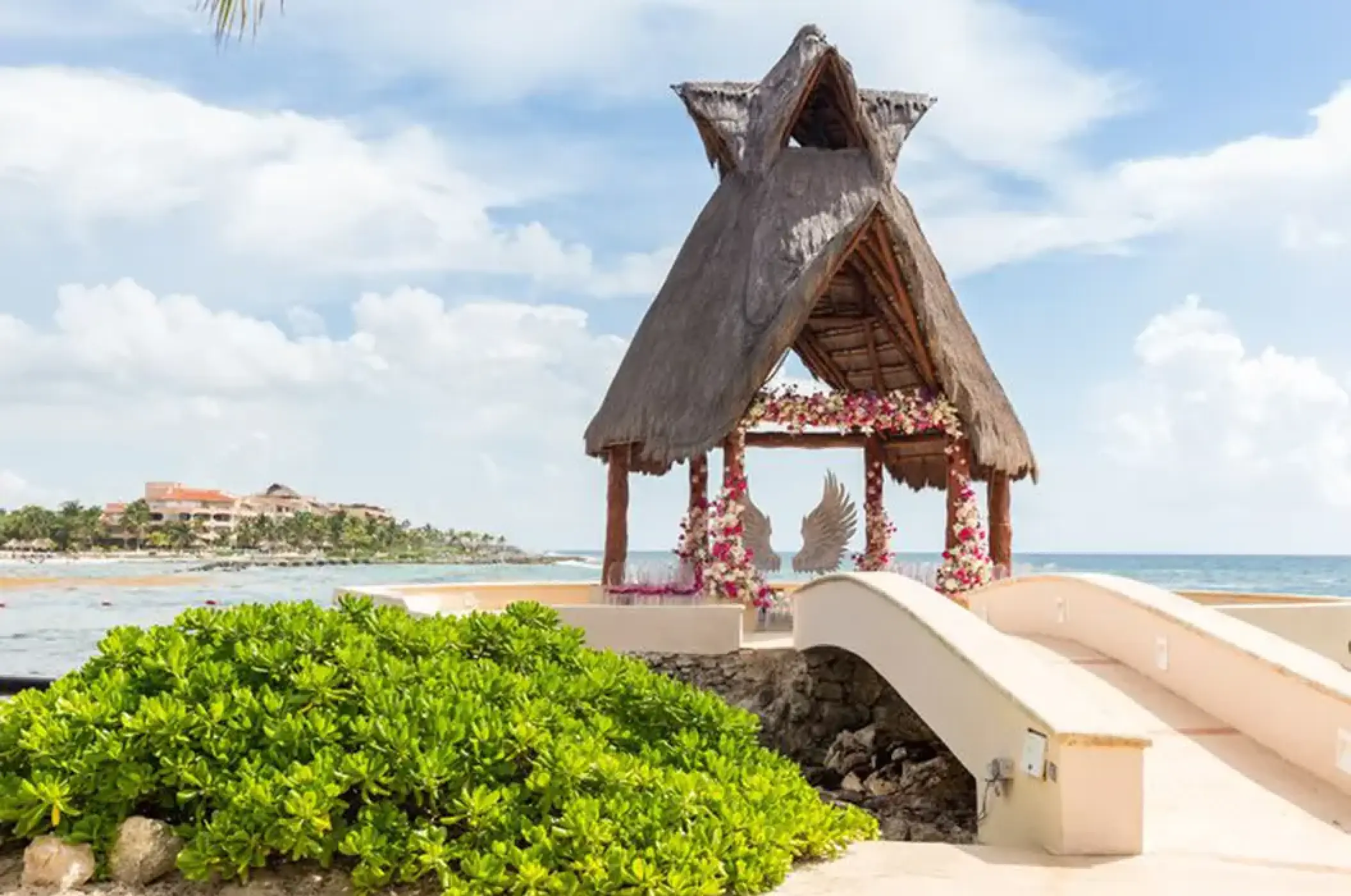 Thatched roof wedding gazebo with floral decor and ocean views at Dreams Aventuras, Riviera Maya