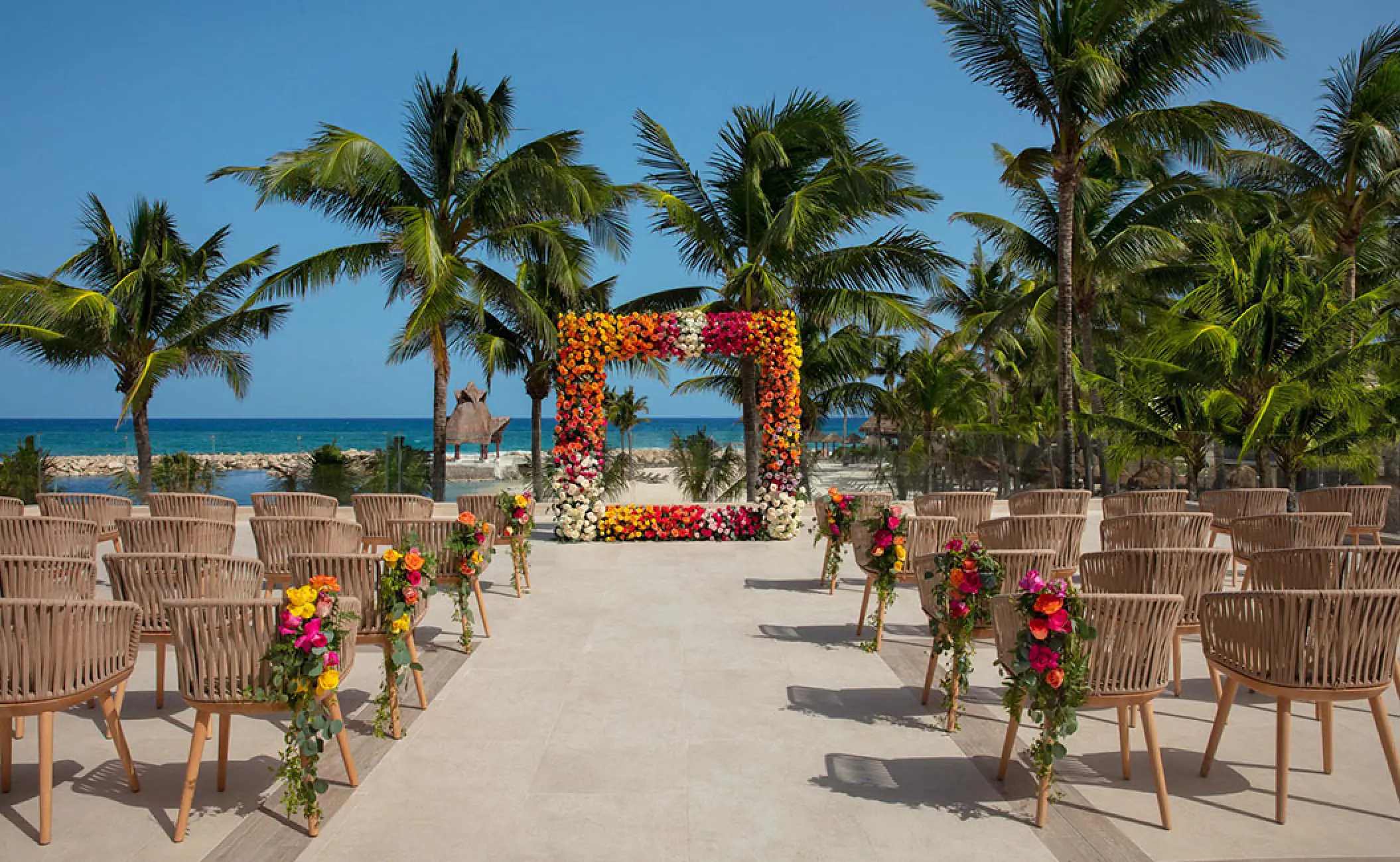 Colorful floral square arch for a terrace wedding ceremony at Dreams Aventuras, Riviera Maya