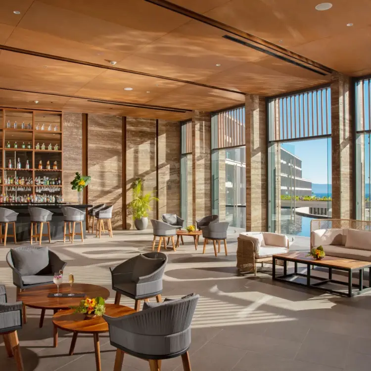 Indoor lobby bar and lounge area with floor-to-ceiling windows at Dreams Bahia Mita, Puerto Vallarta