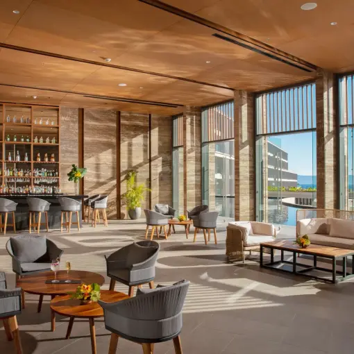 Indoor lobby bar and lounge area with floor-to-ceiling windows at Dreams Bahia Mita, Puerto Vallarta