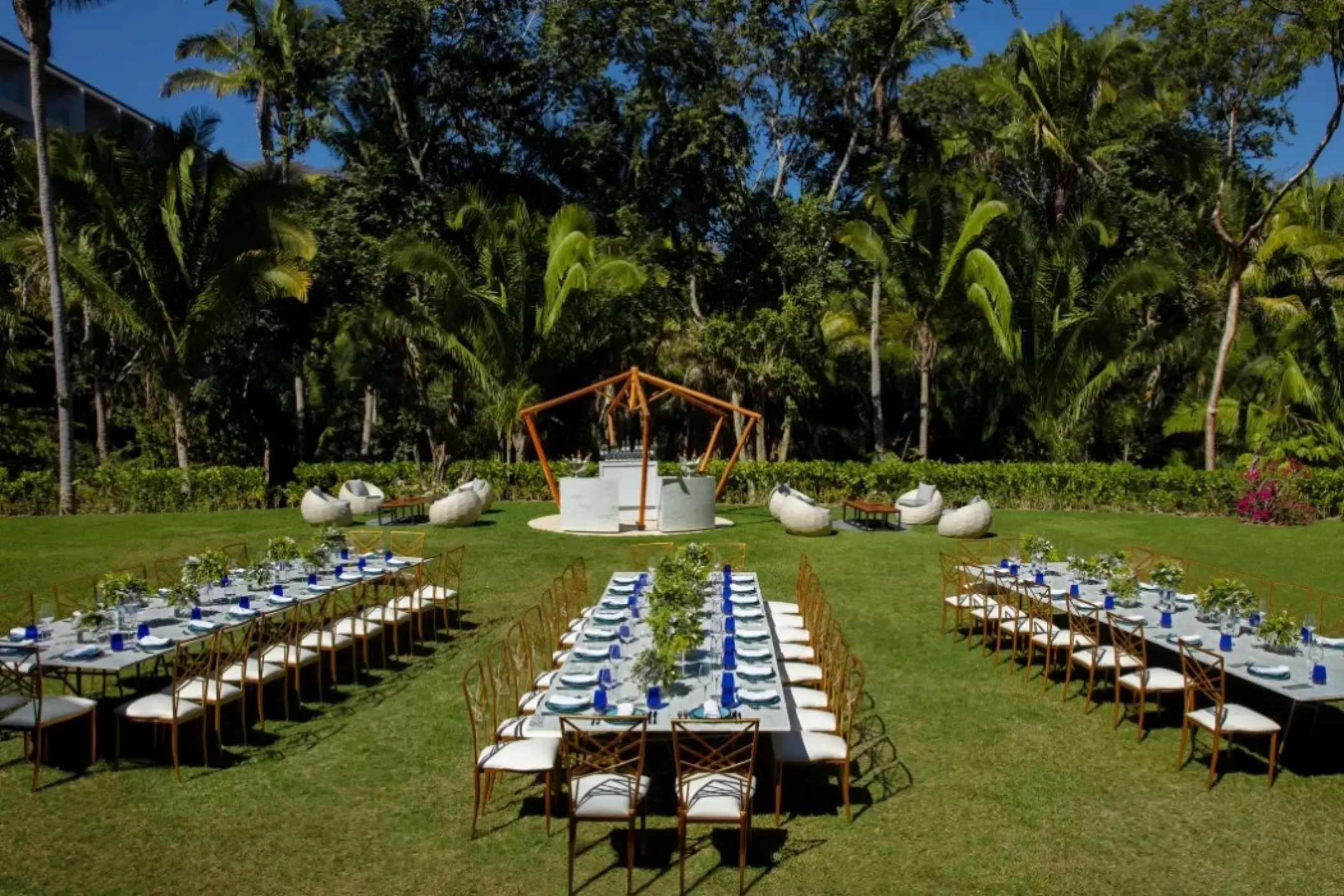Garden wedding reception with long tables and blue glassware at Dreams Bahia Mita, Puerto Vallarta