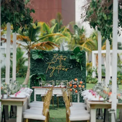 Garden wedding reception at Dreams Cap Cana, Punta Cana featuring long wooden tables and a greenery backdrop