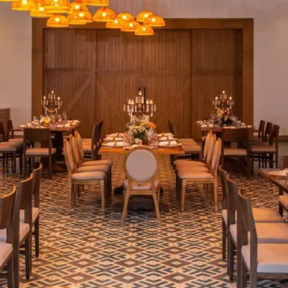 Indoor restaurant wedding reception setup with wooden tables and candelabras at Dreams Cap Cana, Punta Cana