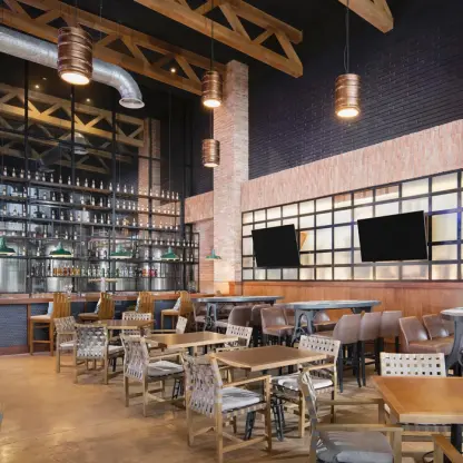 Industrial-style sports bar with brick accents and wooden tables at Dreams Cap Cana, Punta Cana