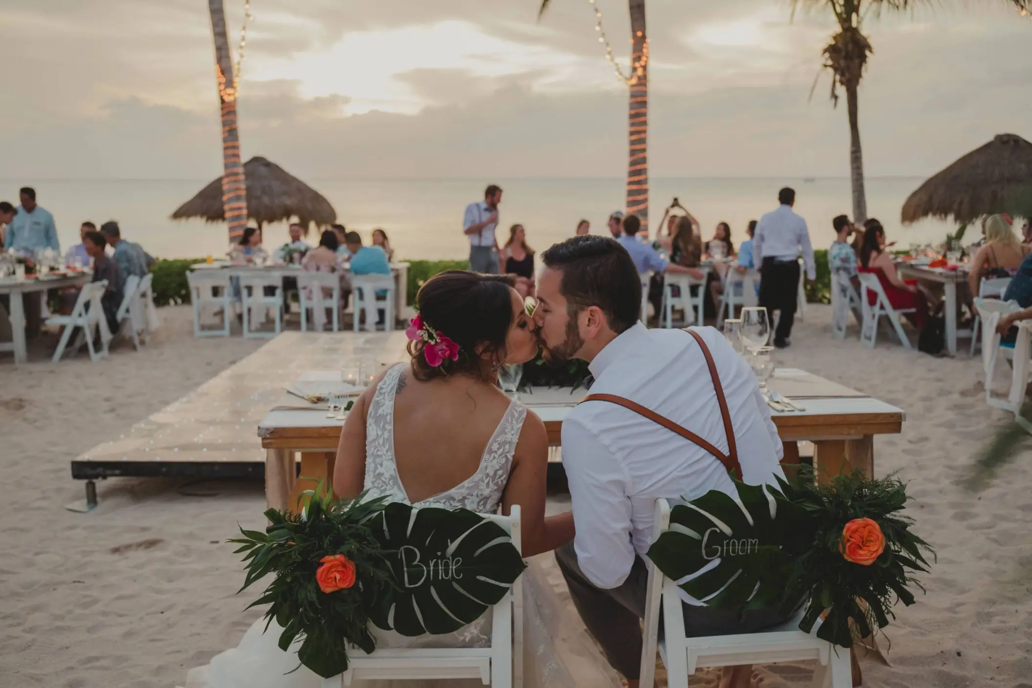 Bride and groom kissing at a beach reception at Dreams Cozumel, Cozumel