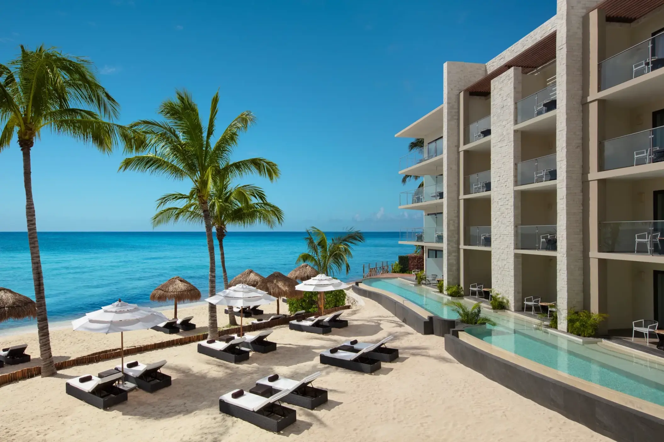 Dreams Cozumel Cape beachfront swim-out suites and lounge chairs on the beach, Cozumel