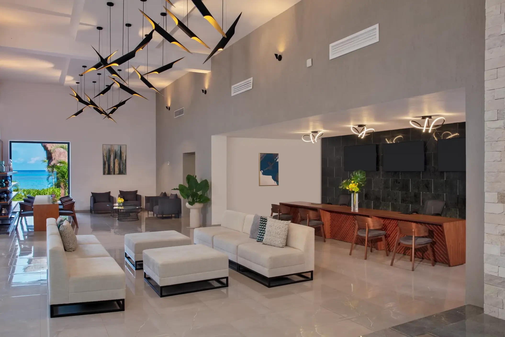 Modern open-concept lobby with white sofas and artistic lighting at Dreams Cozumel, Cozumel