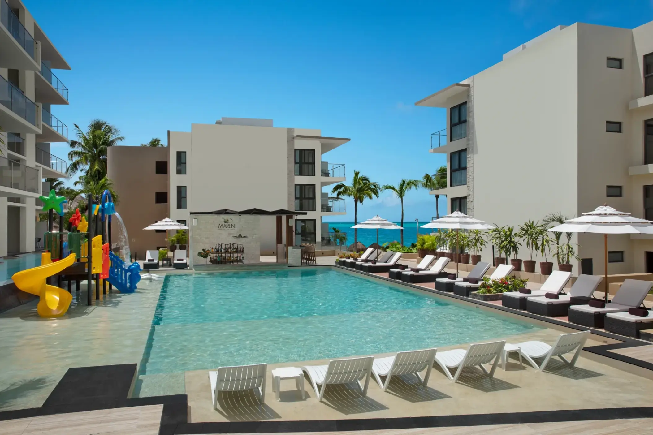 Main swimming pool with water slides and lounge chairs at Dreams Cozumel Cape, Cozumel